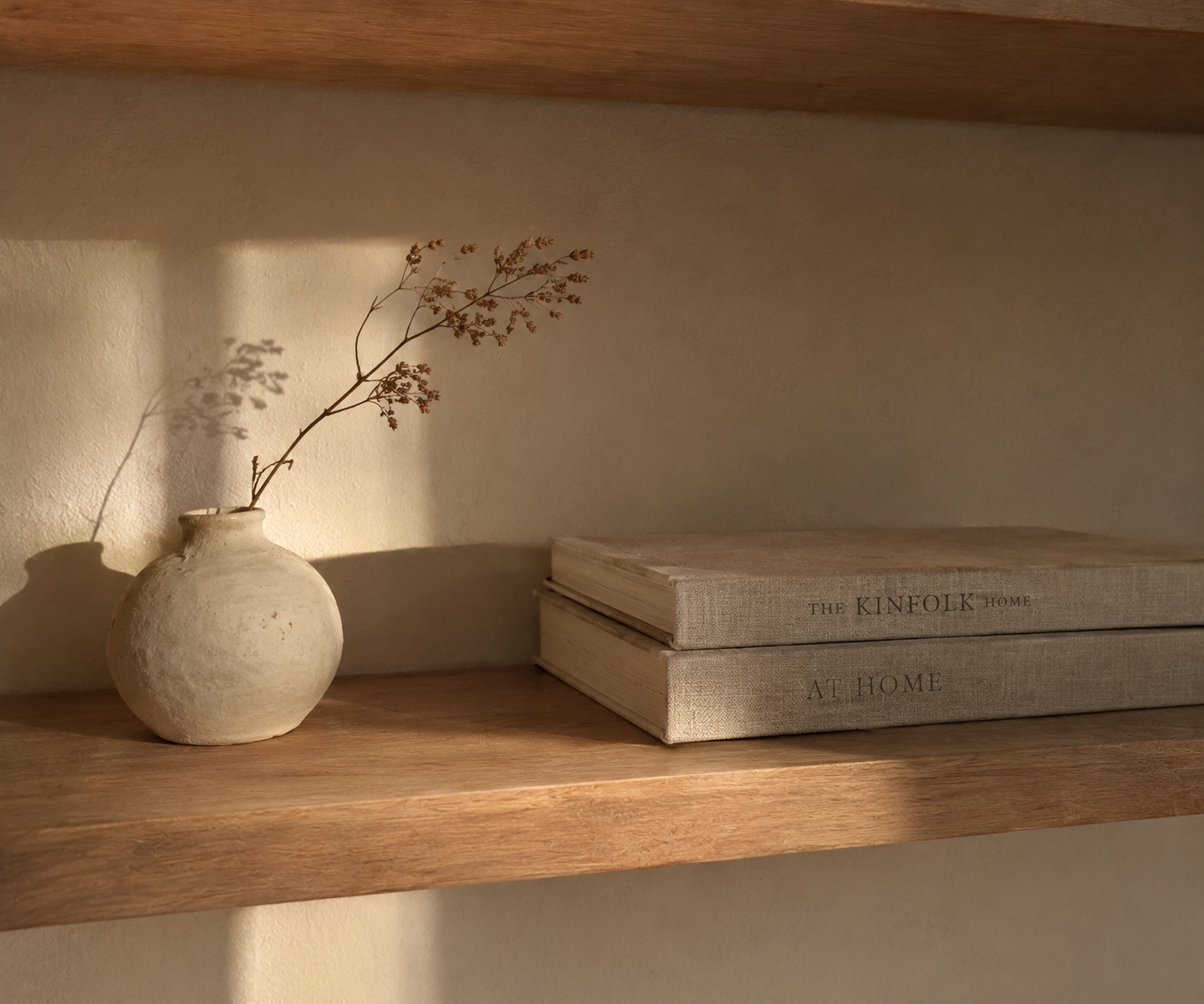 Original photograph of a ceramic vase, books, and a dried branch on a shelf